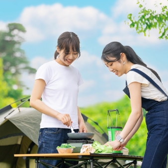 女性キャンパーが料理を楽しむ写真